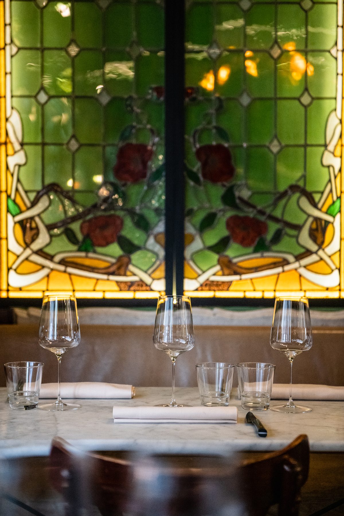 Le vitrail Art nouveau du Bistrot Flaubert au-dessus d'une table dressée